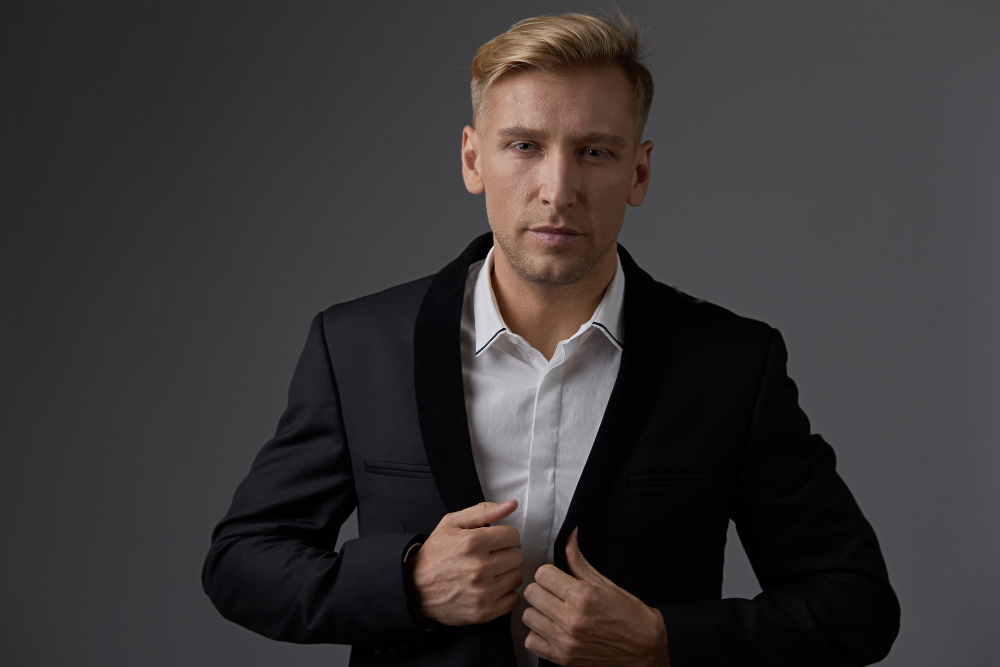 Mężczyzna w czarnej marynarce i białej koszuli.